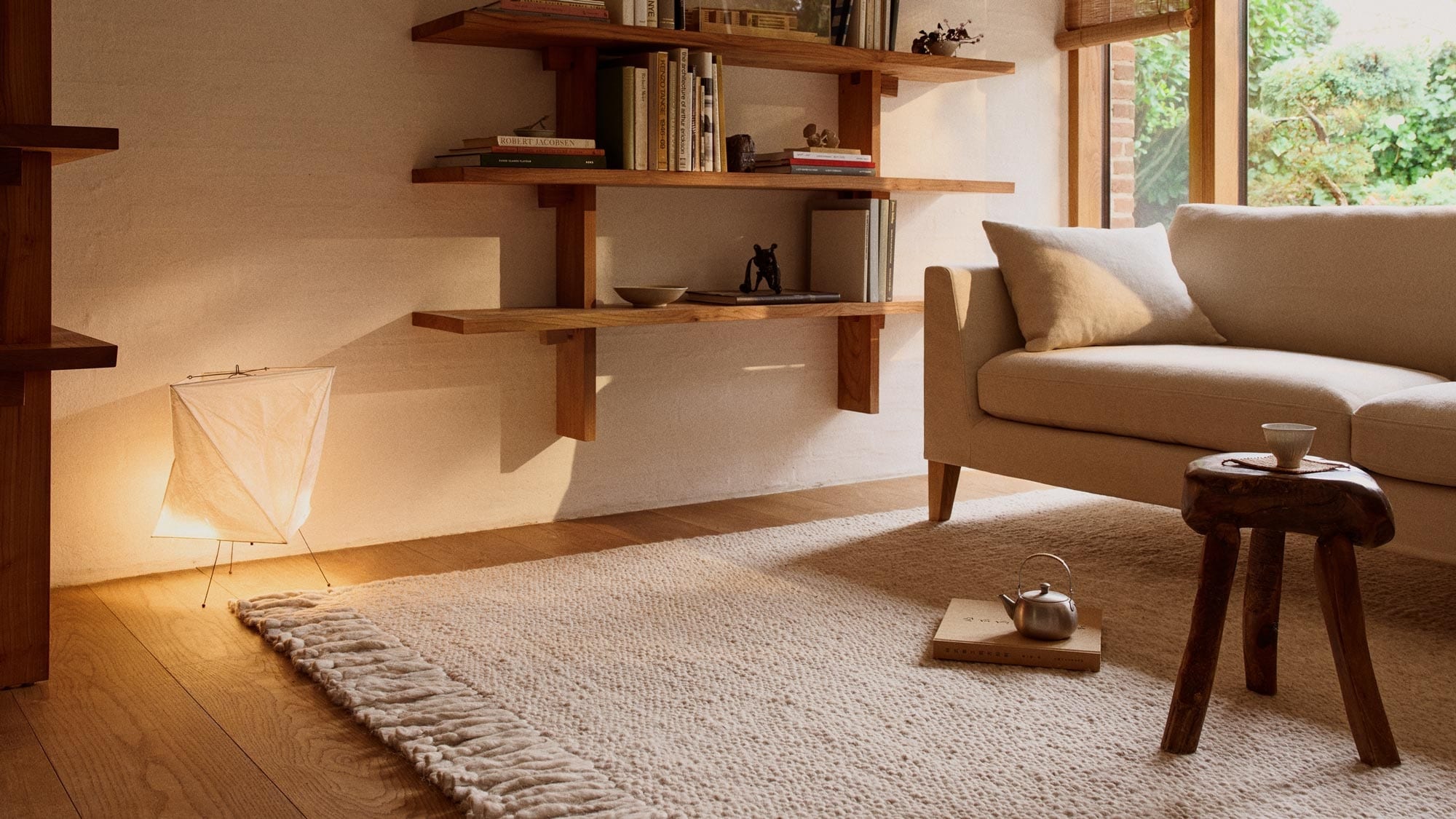 Stue med sofa, hylle og stort, hvitt teppe