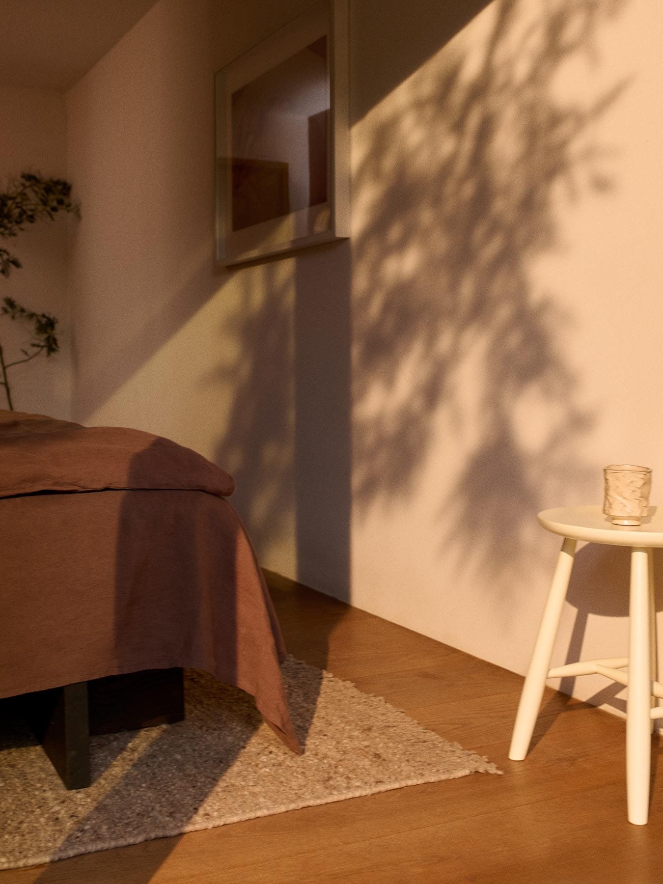 beige ullteppe og krakk ved fotenden av sengen