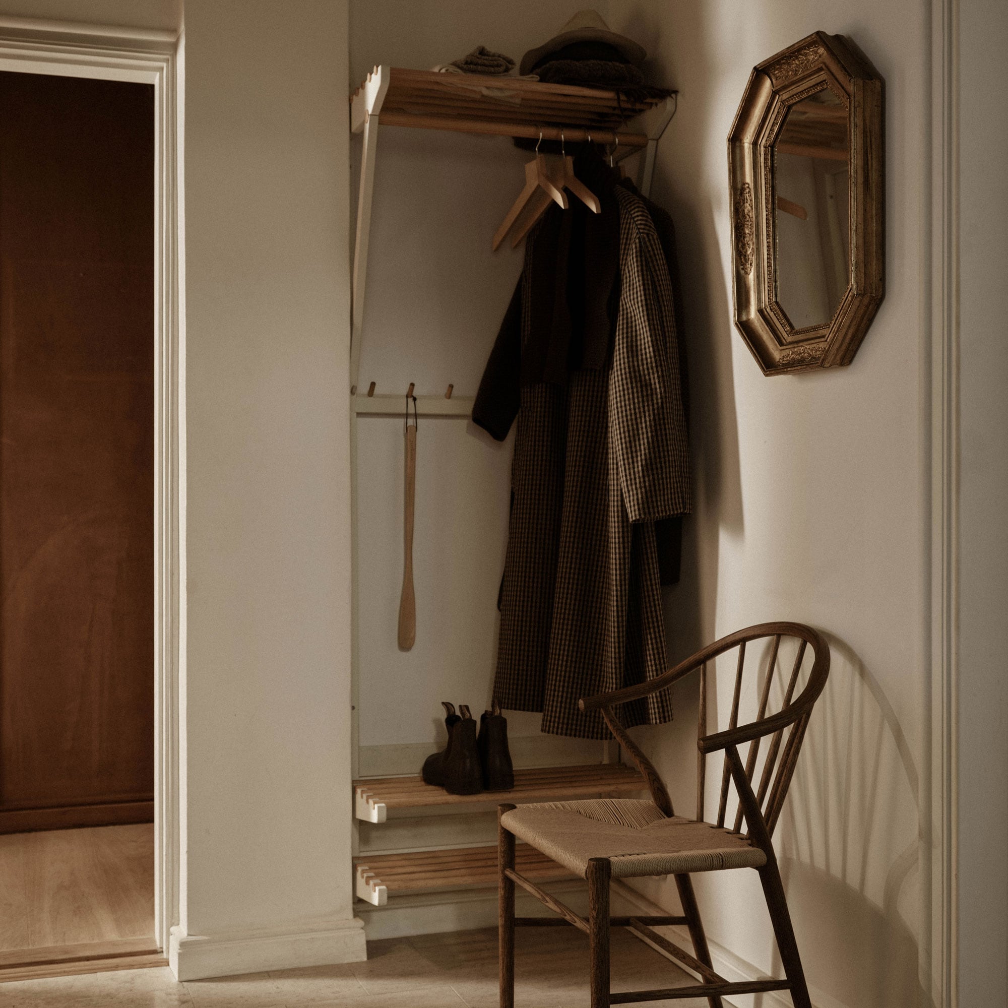 Hatt- og skohylle i en gang med en stol ved siden av